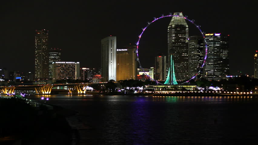 SINGAPORE - DECEMBER 1: Cityscape at night, featuring the landmark Flyer giant wheel in front of downtown high-rise buildings on December 1, 2009 in Singapore. View from Marina Barrage.