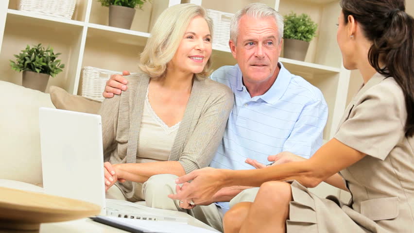 Mature caucasian couple having home meeting with female financial advisor