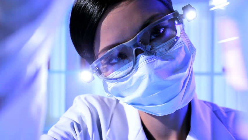 Asian chinese laboratory assistant in protective mask and glasses checking research results