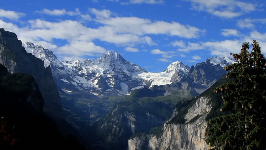 Smooth timelapse of Breithorn Mountain in the Jungfrau Valley of Switzerland's Alps. Beautiful mountains, clouds, blue sky, forest greens and waterfall.