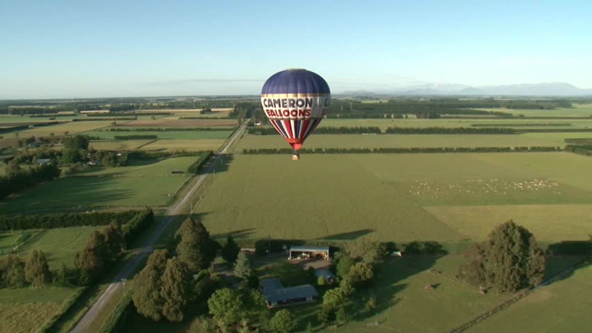 CHRISTCHURCH, NEW ZEALAND - SEPTEMBER 2011 Zooming over the top of a hot air balloon flying over Canterbury farmland as it comes into land