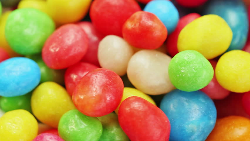 Multicolor bonbon sweets (ball candies) rotating food background, closeup view