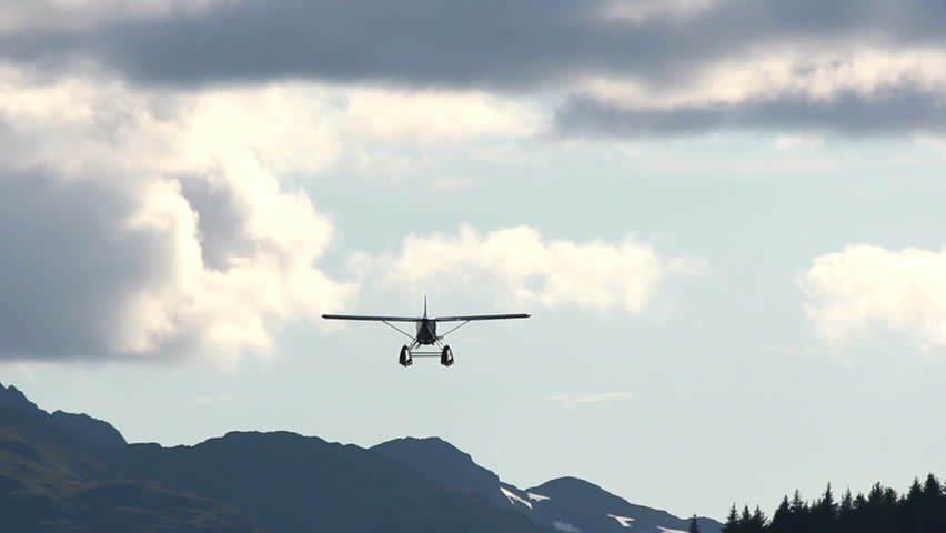 Plane flies over mountains, swoops in for a landing on Kodiak Island, Alaska.