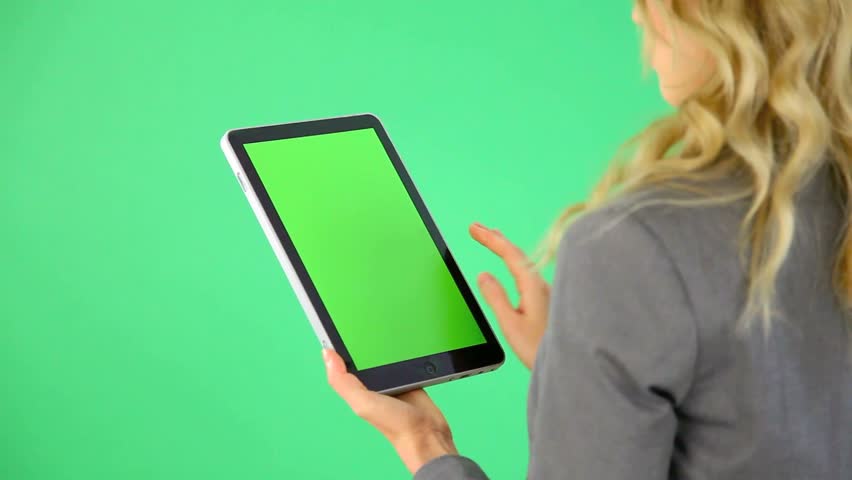Backview of businesswoman on green background with digital tablet