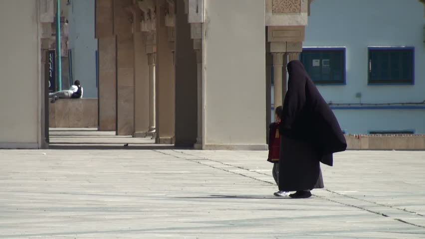 CASABLANCA, MOROCCO - MARCH 12: A Muslim woman and a little boy walk hand in hand on a square near Hassan II Mosque on March 12, 2011 in Casablanca, Morocco.