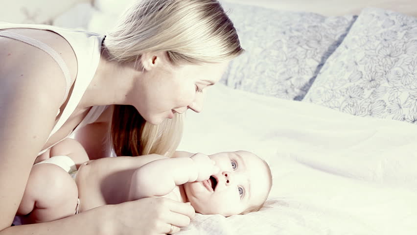 Happiness baby and mother on the bed