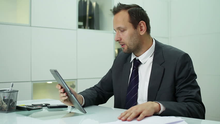 Businessman chatting on tablet computer in the office