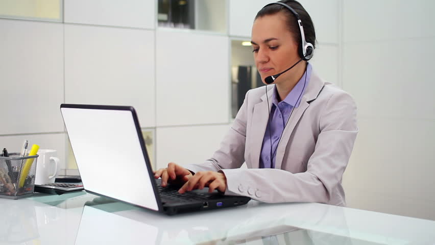 Young helpdesk consultant with headset smiling to camera