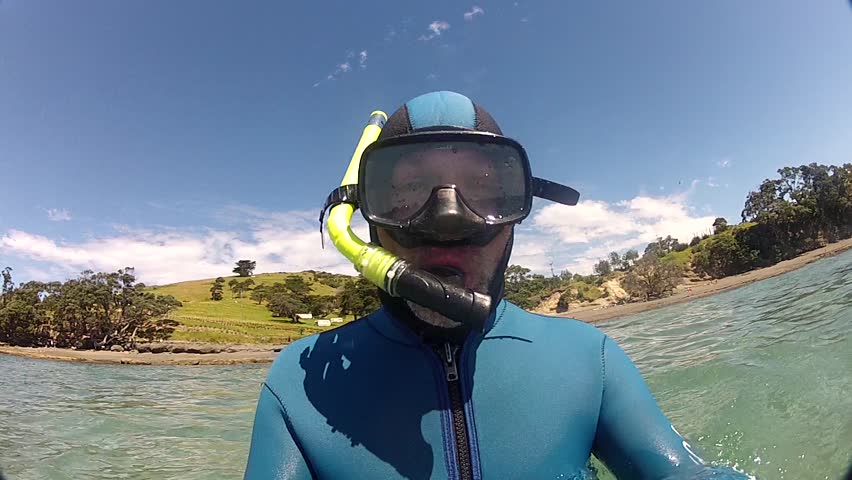 A Snorkeler enters the water at marine reserve Goat Island New Zealand