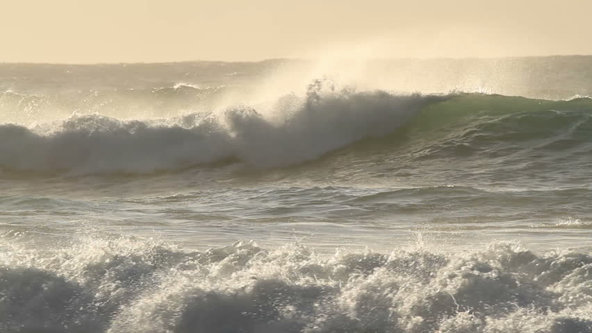 Large coastal waves and water spray during a storm with strong winds 