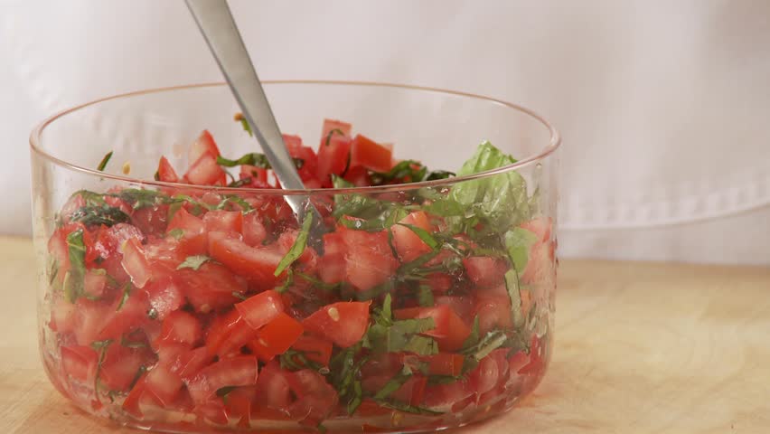 Basil and tomatoes being mixed together