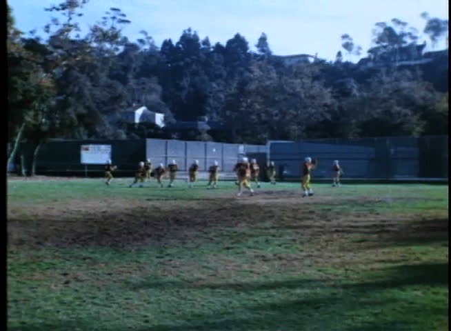 Wide shot of high school football team practicing