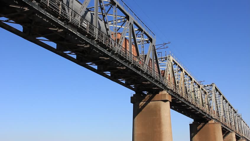 A cargo train crosses a bridge