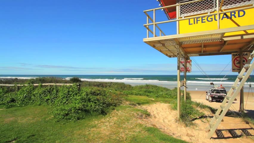 Sunny view of beach with life guard tower and car, Queensland, Australia HD