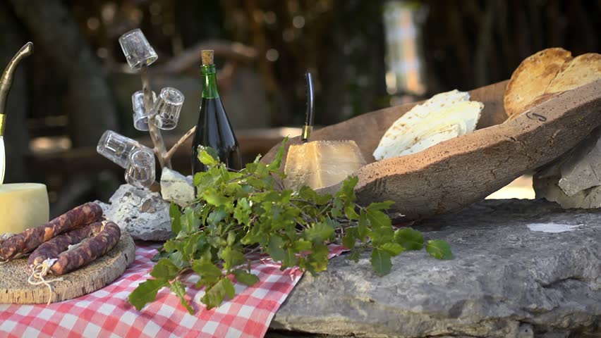 Cheese, ham, salami and wine, traditional food from Sardinia, Italy. Dolly shot. Sequence