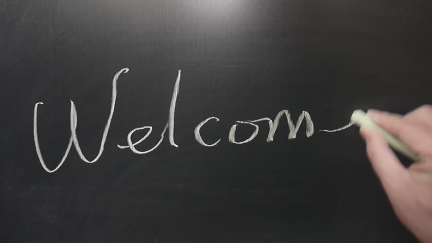 Hands writing "Welcome" word on chalkboard
