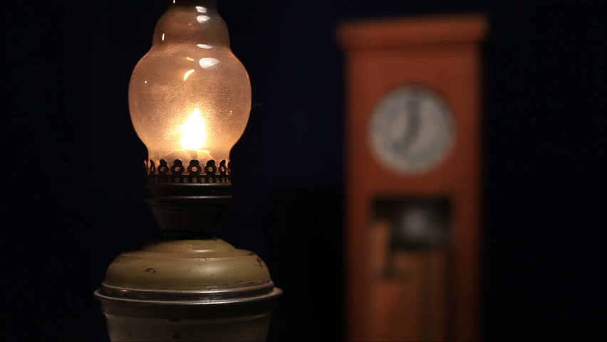kerosene lamp on the background of the old clock 2