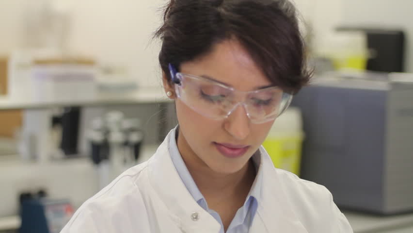 Scientist dropping liquid into vial in genetic laboratory