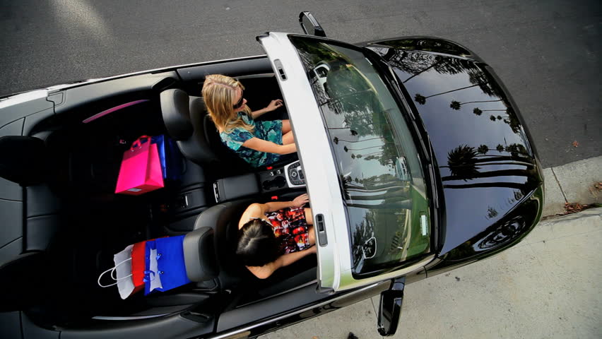 Girls driving off in luxury sports car with designer shopping bags from Rodeo Drive 