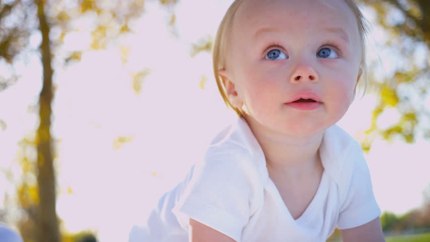 Portrait in close up of cute blonde caucasian baby enjoying the outdoors