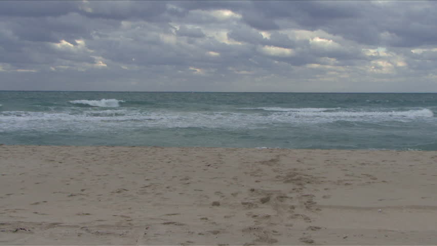Male taking his suit off and running into an ocean