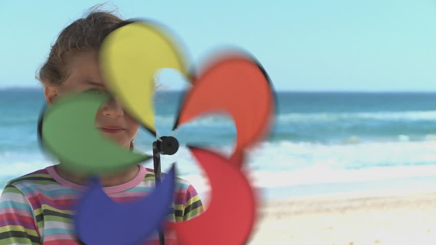 MEDIUM CLOSE UP OF A GIRL SPINNING A PIN WHEEL