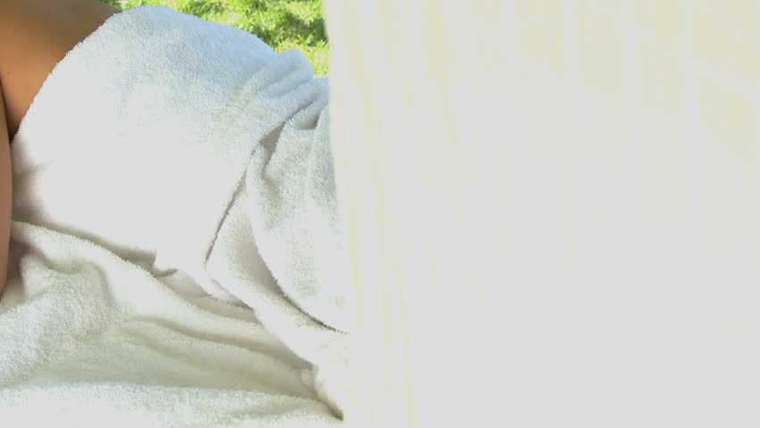 MEDIUM SHOT OF A YOUNG WOMAN LYING ON A MASSAGE TABLE