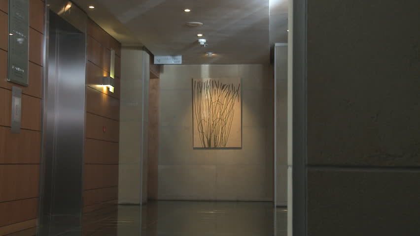 LONG SHOT PAN OF BUSINESSPEOPLE GETTING INTO A LIFT