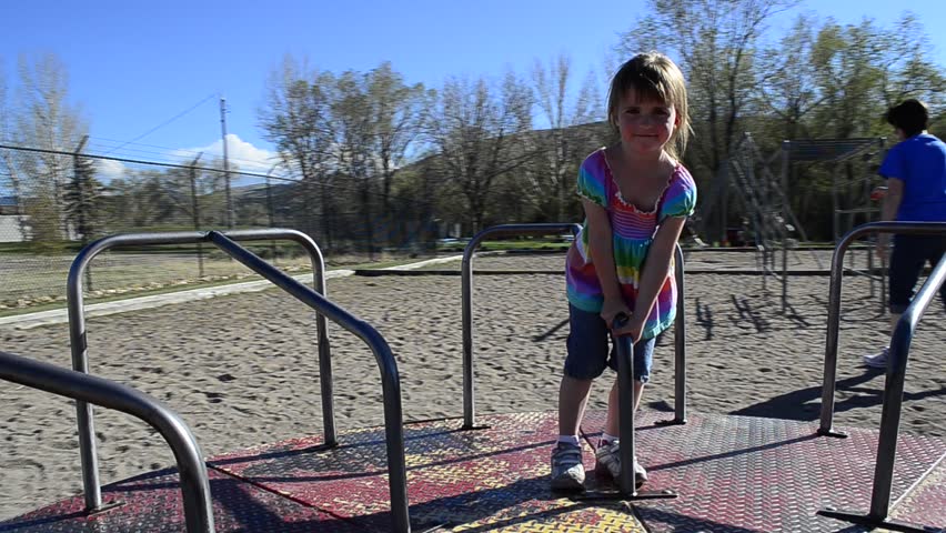 HD Video of little girl spinning on merry go round in park