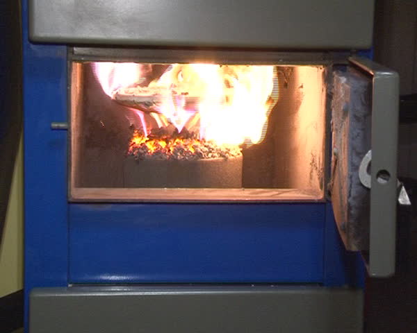 burning straw granules in boiler. flames and fire details. ecologic fuel use for house heating.