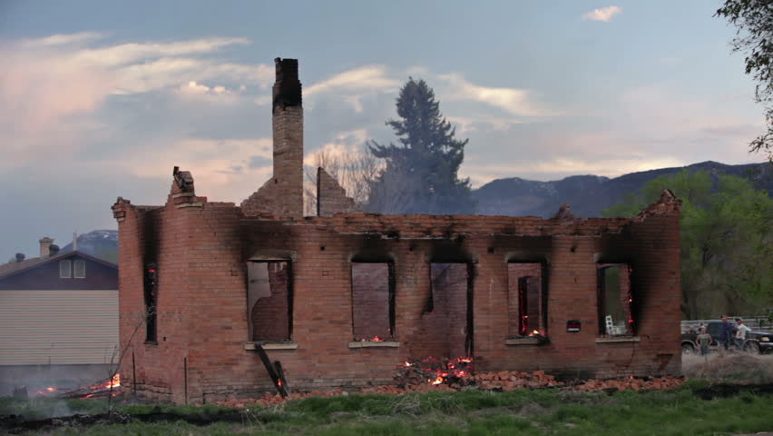 House burning after roof collapse with old adobe bricks walls