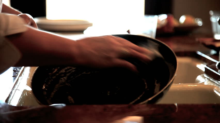 Person washing out non-stick pan over sink