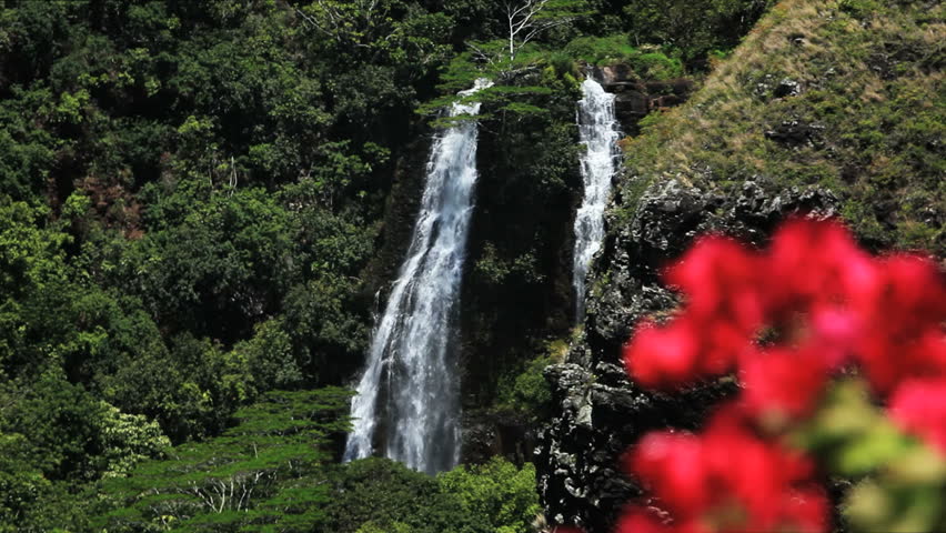 water is cascading from twin waterfalls into a small canyon