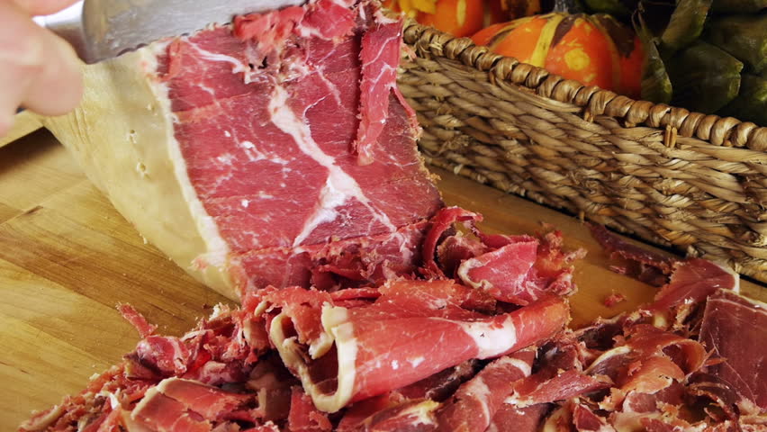 Prosciutto Ham Leg Carved (HD). Boneless Pork Serrano or prosciutto ham leg carved on a wood board. These ham "Jamon" legs are a Spanish delicacy and sold from 100 to thousands of dollars.