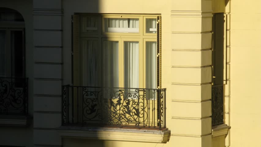 Balcony of building disappears in shadow from sun, time lapse