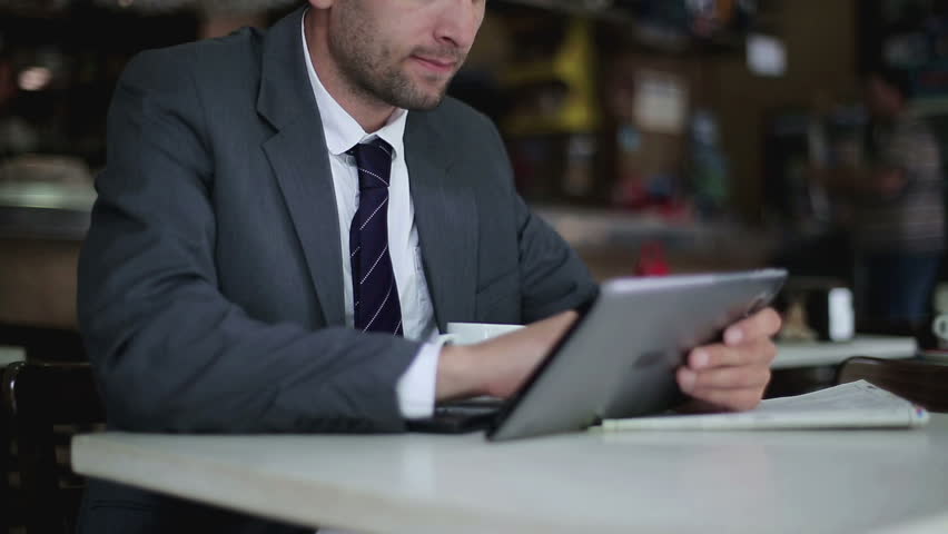 Businessman working on tablet computer in the cafe, steadicam shot
