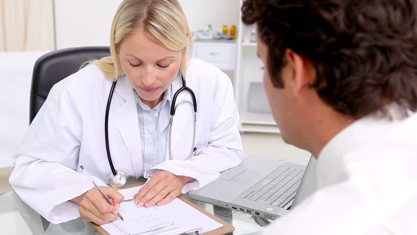 Serious doctor giving a prescription to her patient in her medical office