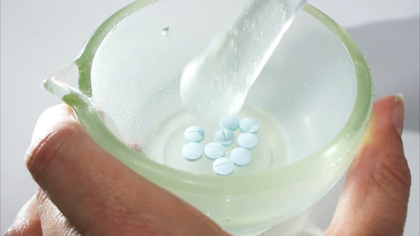 a pharmacist crushes pills to prepare a suspension