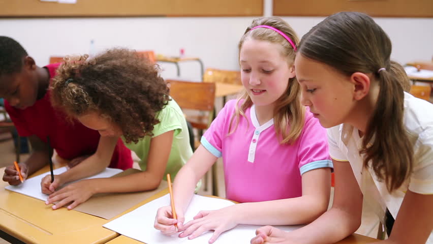 Happy pupils working together in the classroom