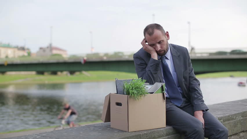 Just fired, unemployed sad young businessman sitting in the city
