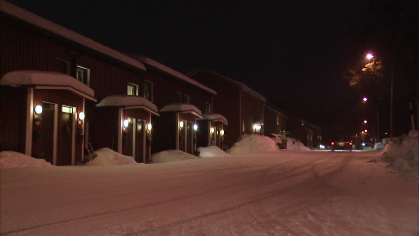 A car skids on a snow covered road outside a house in the winter, Sweden.