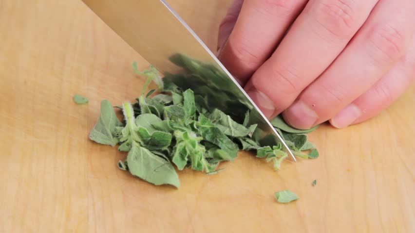 Finely chopping oregano leaves