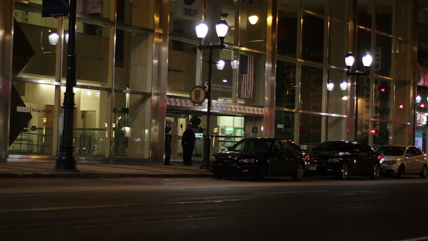 PHILADELPHIA, USA - OCTOBER 22: A person sits at the bus stop on 12th and Market Street on October 22, 2011 in downtown Philadelphia, USA, at night. Sirens sound in the background. 