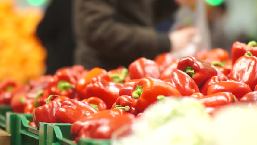 Peoples shopping in supermarket in fruits and vegetables department. Slow motion