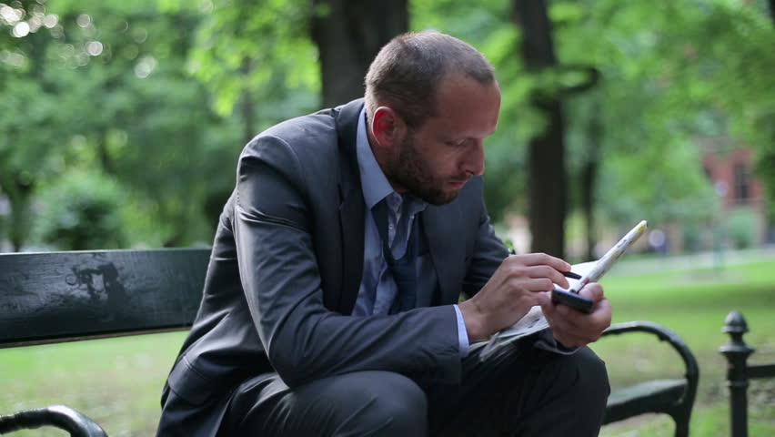 Just fired, unemployed businessman looking for job in newspaper
