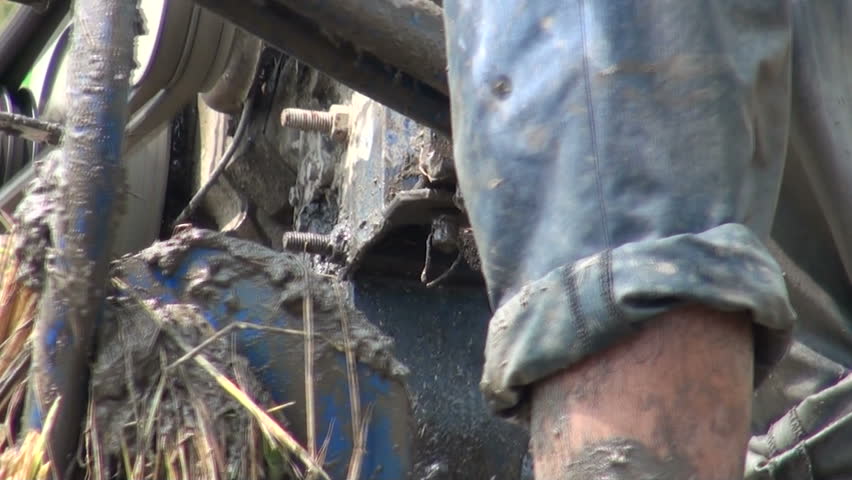 A man is using a machine to plough his land in a rural village in China