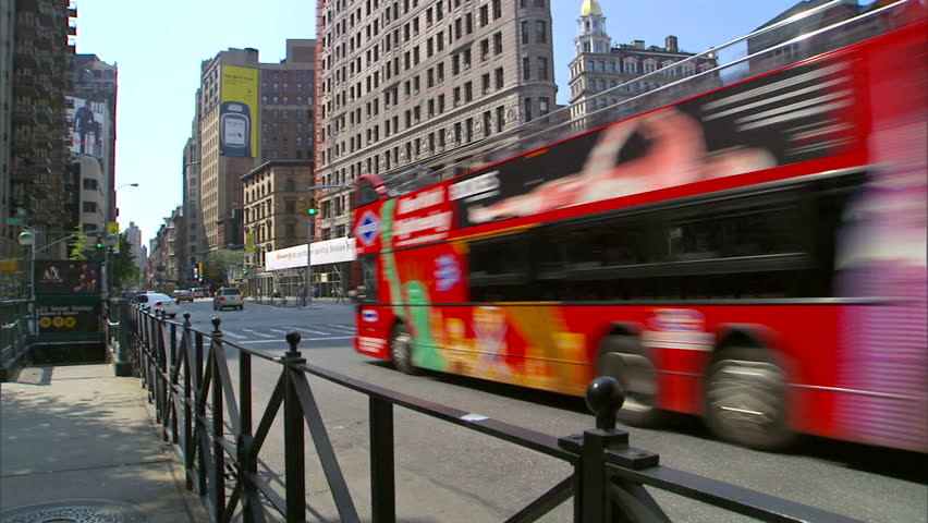 New York, NY - CIRCA 2006: Tilt up of the Flatiron building in Manhattan during the day with traffic driving past
