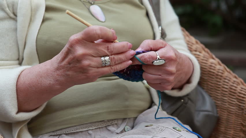 hands of old woman knitting wool, close up