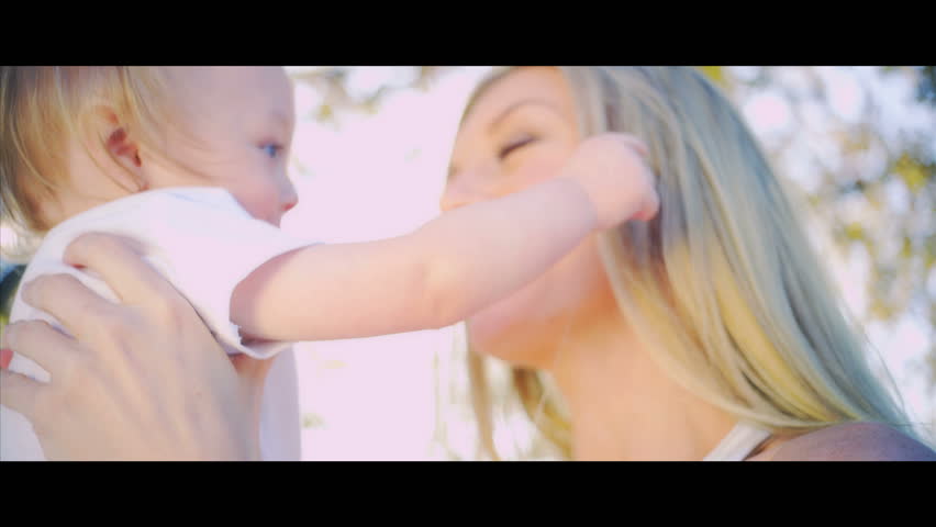 Portrait in close up of young blonde mother outdoors with her smiling baby shot in 5K widescreen RED EPIC