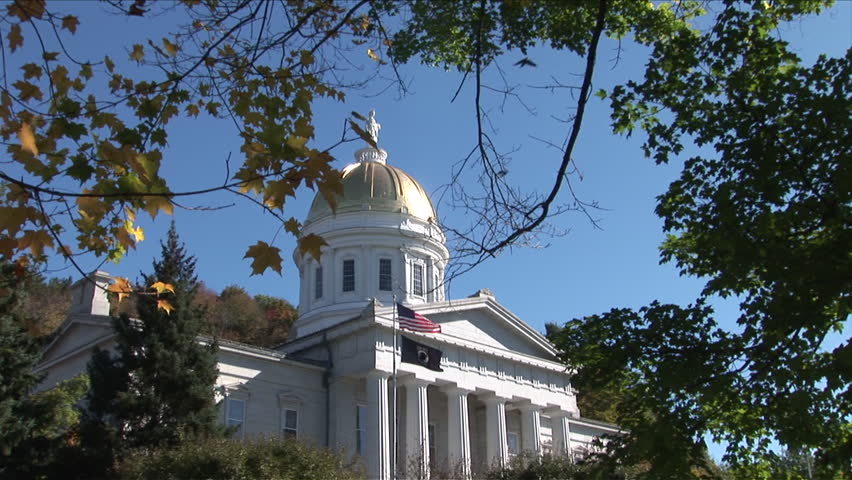 Montpelier, Vermont - CIRCA September 2007: Zoom out of the State Capitol Building sitting on a green lawn with trees during the day